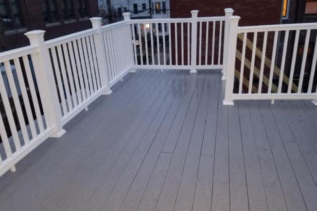 Custom rooftop deck with white railings and composite decking